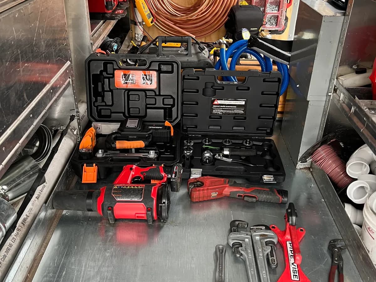 Close-up of pressure-test and refrigerant service tools organized in a service kit
