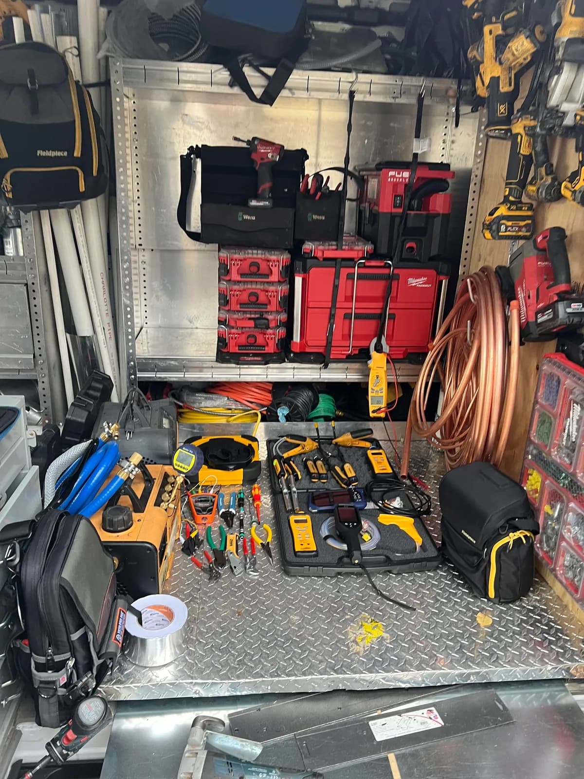 Inside an Eco Air Zone service truck — Milwaukee Packout system, gauges, hoses, and diagnostic tools laid out and ready